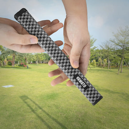 White Yamato golf grip resting on grass with putter