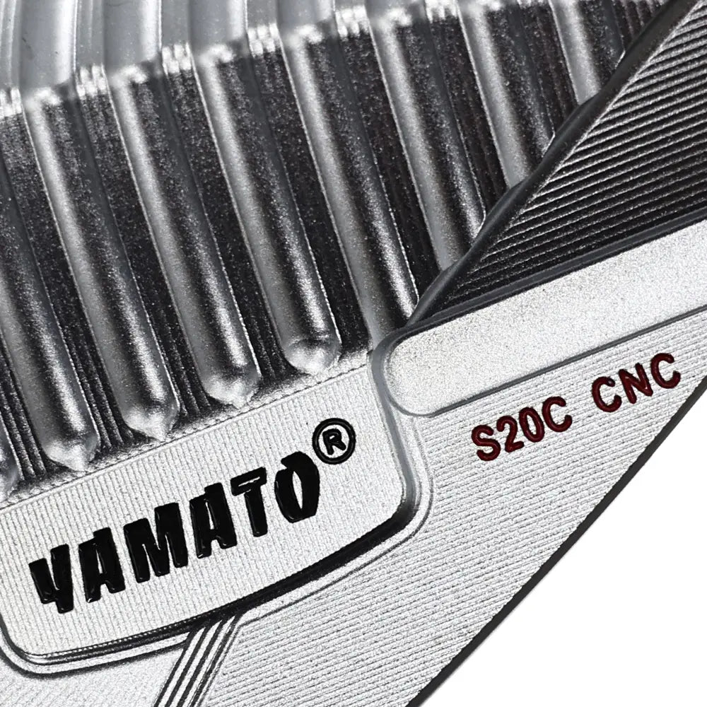 Close-up of Yamato wedge back showing engraved brand logo on polished surface