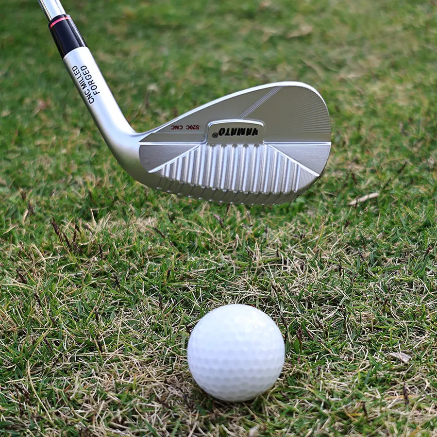Yamato forged golf wedge standing upright on grass next to golf ball