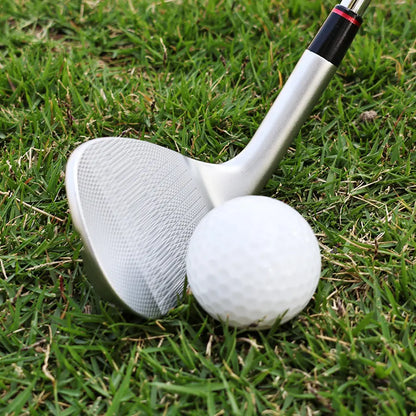 Yamato wedge positioned next to golf ball on grass, ready for chip shot
