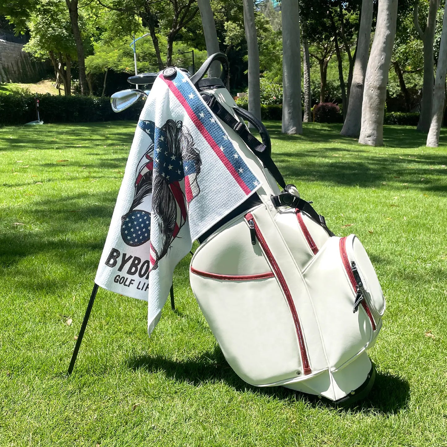 Yamato magnetic golf towel with American flag design attached to golf cart, showing strong magnet clip in use.